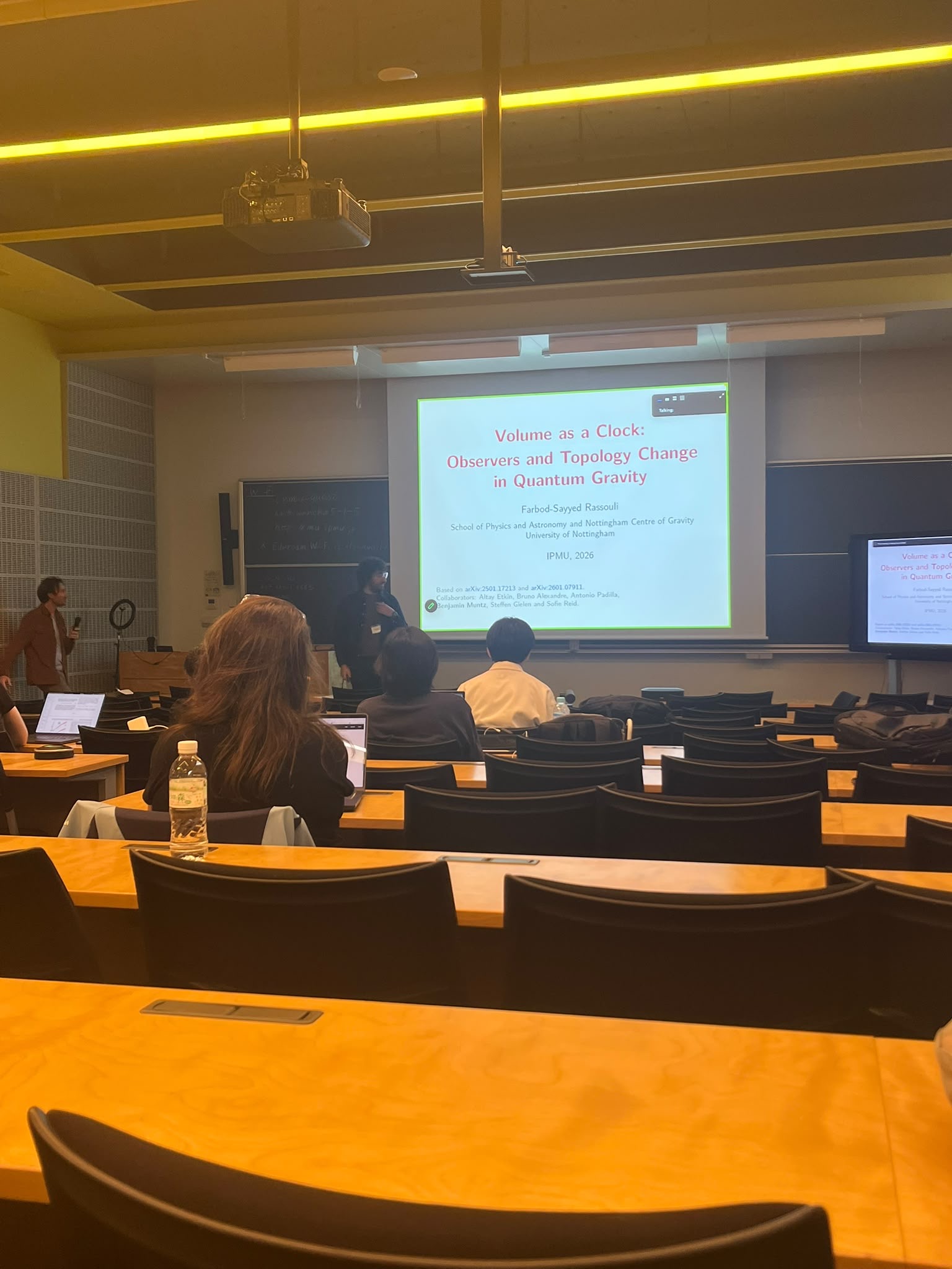 Farbod Rassouli presenting Volume as a Clock at Kavli IPMU, with the title slide behind him.