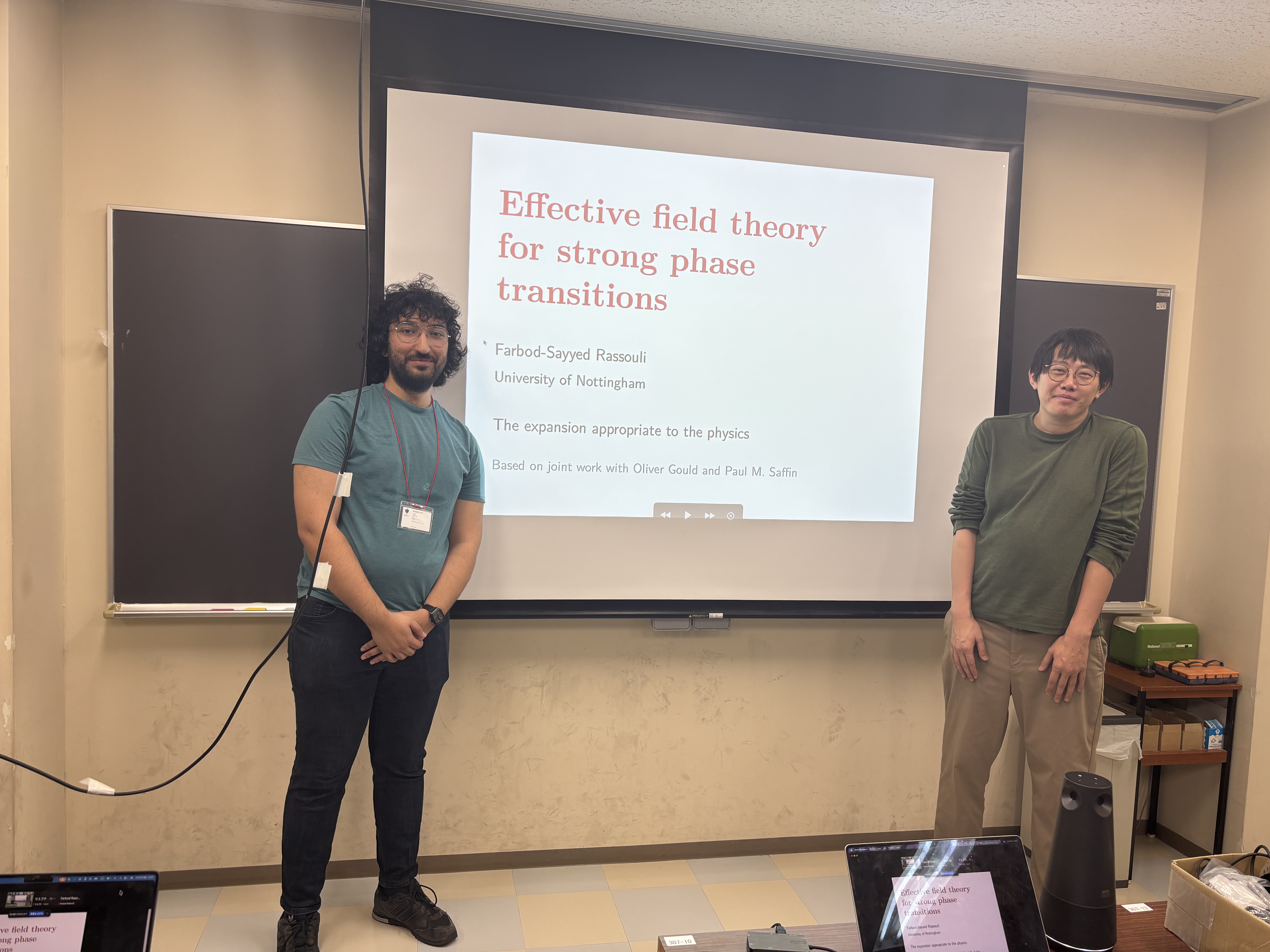 Farbod Rassouli beside his EFT talk title slide at Tokyo Metropolitan University.